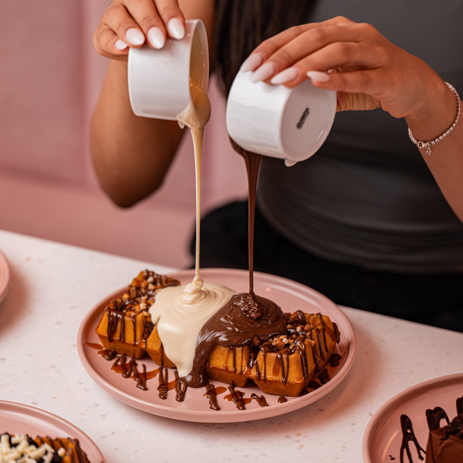 Sauce being poured over a fresh Doorstep Desserts waffle